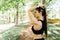 Woman tying hair in ponytail getting ready for exercising in park. Beautiful young sporty woman attaching her long hair in park. S