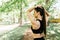 Woman tying hair in ponytail getting ready for exercising in park. Beautiful young sporty woman attaching her long hair in park. S
