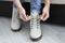 Woman tying shoelaces on white warm shoes closeup