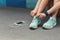 Woman tying shoes laces before running top view