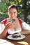 Woman in typical Bavarian costume eats bread with chives in a Ba