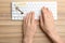 Woman typing on keyboard at wooden table, top view. Keyword concept