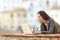 Woman typing on a laptop in a balcony