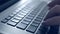 Woman typing on laptop. Closeup on hands. Blue tone