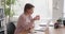 Woman typing on laptop and drinking coffee at office