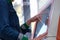 Woman typing pin code on screen of ATM closeup