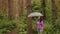 A woman with an umbrella in her hand in the rain. A girl in a purple shirt under an umbrella in the woods. A woman with