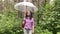 A woman with an umbrella in her hand in the rain. A girl in a purple shirt under an umbrella in the woods. A woman with