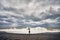 Woman with umbrella near stormy sea