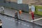 Woman with umbrella during Raining day wet street, construction project in fischerinsel