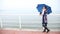 Woman with umbrella relaxing on the pier. Sea.