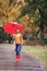 Woman with umbrella taking walk in autumn park