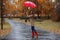 Woman with umbrella taking walk in autumn park