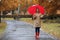 Woman with umbrella taking walk in autumn park