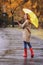 Woman with umbrella taking walk in autumn park