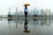 Woman with umbrella watching Shanghai, China