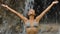 Woman under waterfall in tropical nature