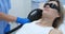 Woman undergoes hair removal procedure with photoepilator or laser hair removal of armpits in salon