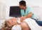 Woman undergoing examination thyroid lying by man doctor with ultrasonic device