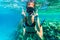 Woman underwater snorkeling with victory happy sign swimming in sea