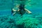 Woman underwater snorkeling wgesturing victory swimming in sea