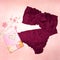 Woman underwear burgundy set bra panties on pink floral towel