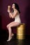 Woman in underwear sitting on gold barrel