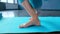 A woman unfolds a rug for practicing yoga in the studio.