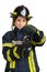 Woman in uniform, hardhat of firefighter opens valve on fire hose nozzle