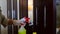 Woman in uniform and rubber white gloves washes cabinet handles.