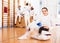 Woman in uniform sitting on floor at fencing training