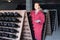 Woman in uniform working with bottle storage racks in winery cellar