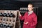 Woman in uniform working with bottle storage racks in winery cellar