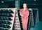 Woman in uniform working with bottle storage racks in winery cellar