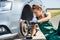 Woman in uniform working for car brake maintenance. Car repair. Safety work