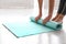 Woman unrolling mat in yoga studio