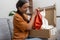 woman unwraps her package, enjoying her online clothing haul with express delivery service.