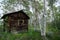 Woman urban explorer smiles through a broken window in an old log cabin in Miners Delight Wyoming