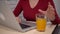 Woman use laptop, freelance distance remote working, drinking orange juce