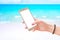 Woman use smart phone.  screen for mockup. Close-up scene with a beach in the background