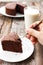 Woman used fork picking chocolate cake. Baked and desssert background.