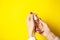 A woman uses antiseptic on yellow background