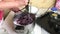 A woman uses a blender to puree blueberries and sugar. Making blueberry jam at home. Preservation and preparation of blueberries
