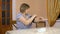 A woman uses a device to measure heart pressure. An elderly woman puts a blood pressure monitor on her hand and measures