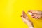 Woman uses hand antiseptic on yellow background