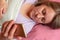 Woman uses mobile phone in a bed. Middle aged 40 years woman lying on pillow and read on smartphone. Social networking or internet