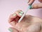 A woman uses a nail file to put her nails in order on a paper pink background. Nail care at home