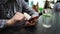 Woman uses phone and drinks water in cafe