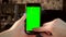 The woman uses the phone. Hand makes swipe up on smartphone with green screen. Chroma key.