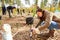 Woman uses a spray can to mark a tree stake for reforestation